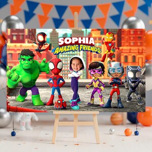 May include: A rectangular party backdrop featuring the text "SOPHIA AND HIS AMAZING FRIENDS" with cartoon characters including Hulk, Spider-Man, Iron Man, Black Panther, and a child's face integrated into a superhero suit in the center.