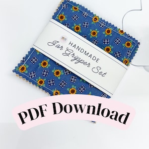 May include: A stack of square fabric jar grippers with pinked edges, featuring a blue background with a pattern of yellow sunflowers and small white grid squares. A white paper band wraps around the center with the text HANDMADE Jar Gripper Set.
