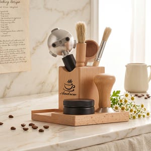 May include: A wooden espresso station with a portafilter, brushes, tamper, and a black puck screen. The station has a coffee cup logo and the name "Andrew" printed on it. Coffee beans and a small white pitcher are also visible.