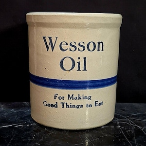 May include: A white ceramic mug with a black handle and the text "But First, Coffee" in a black, bold font. The mug is sitting on a wooden surface. The mug is 4 inches tall.