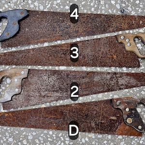 Puede incluir: Cuatro sierras de mano antiguas con mangos de madera y metal. Las hojas de sierra son de color marrón óxido y los mangos varían en color, desde negro hasta madera clara. Las sierras están dispuestas en fila, mostrando su aspecto envejecido.