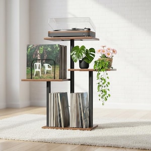 May include: A multi-tiered, black and brown vinyl record storage unit with a turntable, plants, and records. The unit has a turntable on top, records on the shelves, and plants in pots. The unit is on a white rug.