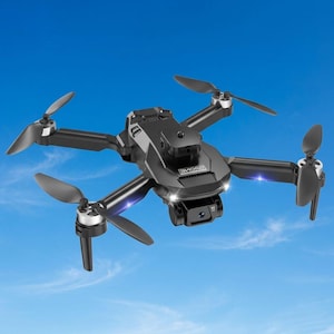 May include: A black quadcopter drone featuring four rotating propellers, a central camera module with a lens, and integrated LED lights on the front arms. The device has a sleek, angular body design with the word DRONE printed on the top surface.