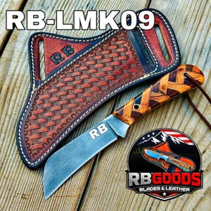 May include: A handcrafted knife with a wooden handle and a leather sheath. The knife blade is silver, and the handle features a woven wood design. The sheath is brown with a woven pattern. The text "RB-LMK09" is visible.