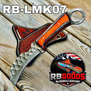 May include: A curved blade knife with an orange and brown handle and a metal ring at the end. The knife rests on a brown leather sheath. The text "RB-LMK07" is at the top. The logo "RB GOODS BLADES & LEATHER" is at the bottom.