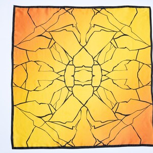 K&ouml;nnte beinhalten: Quadratisches Tuch mit einem lebendigen, abstrakten Design. Es zeigt einen Farbverlauf von Gelb und Orange mit einem schwarzen geometrischen Muster, das an zerbrochenes Glas erinnert. Ein schwarzer Rand umrahmt das Design.