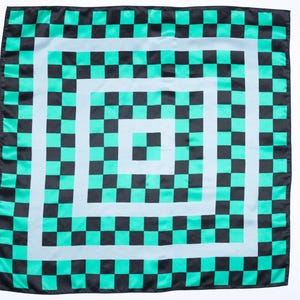 Op de afbeelding: Vierkante sjaal met een herhalend dambordpatroon in zwart en teal. Het ontwerp bevat concentrische vierkanten met afwisselende kleuren, waardoor een gedurfd en geometrisch visueel effect ontstaat. De sjaal is waarschijnlijk gemaakt van een lichte stof.