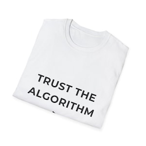 Puede incluir: Camiseta blanca con el texto "TRUST THE ALGORITHM" impreso en negro. La camiseta tiene cuello redondo y está doblada. El texto está centrado en la parte delantera de la camiseta.