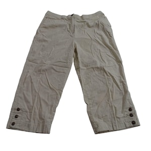 May include: Tan capri pants with a button closure and three buttons on each cuff. The pants have a relaxed fit and are made of a lightweight fabric. The pants have a zipper and button closure at the waist.