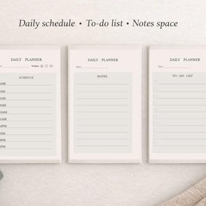May include: Three beige daily planner notepads with the text "Daily schedule • To-do list • Notes space". The notepads include a schedule, notes, and to-do list. A pen, a cup of coffee, and greenery are also in the image.