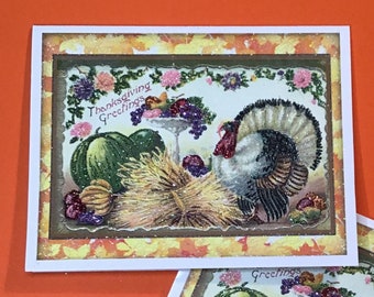 May include: Two Thanksgiving greeting cards with a turkey, pumpkins, and fall foliage. The cards have a glittery finish and say "Thanksgiving Greetings".