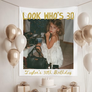 May include: A rectangular birthday banner featuring the gold text LOOK WHO'S 30 and Taylor's 30th Birthday, displaying a vintage photograph of a child in a white dress with a black handbag, surrounded by clusters of metallic gold and white balloons.
