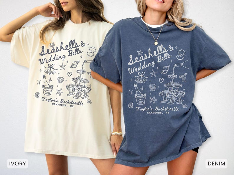 K&ouml;nnte beinhalten: Zwei T-Shirts, eines in Elfenbein und eines in Denim, mit einem wei&szlig;en Grafikdesign. Das Design enth&auml;lt den Text "Seashells & Wedding Bells" und "Taylor's Bachelorette, Hamptons, NY" mit Illustrationen von Champagner und Muscheln.