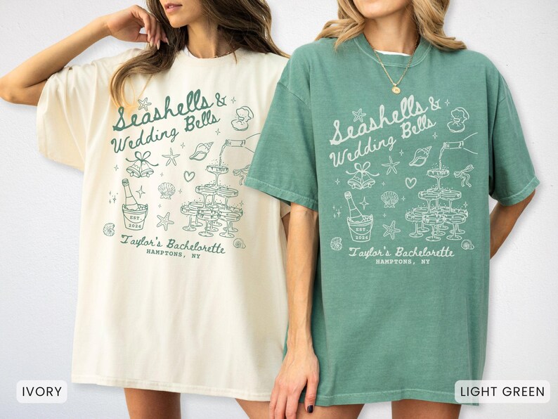 K&ouml;nnte beinhalten: Zwei T-Shirts, eines in Elfenbein und eines in Hellgr&uuml;n, mit dem Text "Seashells & Wedding Bells" und "Taylor's Bachelorette, Hamptons, NY". Das Design umfasst Sektgl&auml;ser, Muscheln und eine Sektflasche.