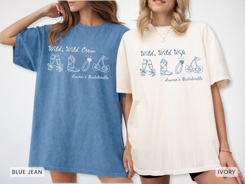 Puede incluir: Dos camisetas holgadas, una azul vaquero y otra marfil, con los textos "Wild, Wild Crew" y "Wild, Wild Wife". Cada camiseta presenta un gr&aacute;fico blanco de copas de champ&aacute;n, una bota de vaquero, un anillo y cerezas. "Lauren's Bachelorette" est&aacute; impreso debajo.