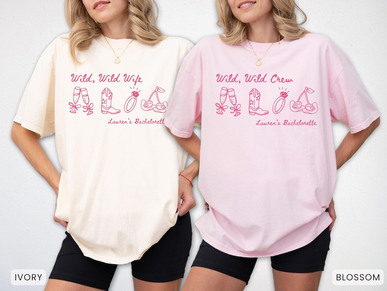 Puede incluir: Dos camisetas, una marfil y otra rosa, con el texto "Wild, Wild Wife" y "Wild, Wild Crew" en escritura rosa. Cada camiseta tiene ilustraciones a juego de copas de champ&aacute;n, botas, un anillo y cerezas. El texto "Lauren's Bachelorette" est&aacute; debajo.