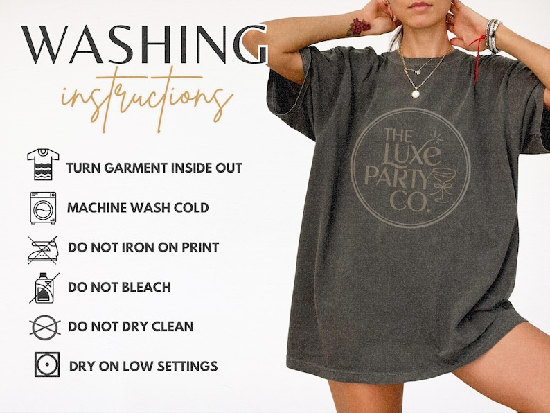 K&ouml;nnte beinhalten: Dunkelgraues T-Shirt mit rundem Logo "The Luxe Party Co." und Waschanleitung. Die Anweisungen umfassen das Wenden des Kleidungsst&uuml;cks, Maschinenw&auml;sche kalt und Trocknen bei niedriger Temperatur.