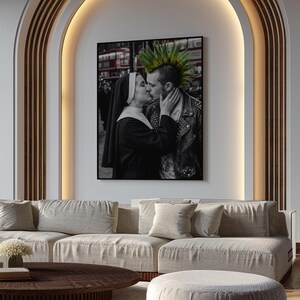 May include: A framed black and white wall art print featuring a nun in a traditional habit kissing a person with a bright green mohawk hairstyle wearing a black leather jacket with metal studs, set against a blurred urban street background.