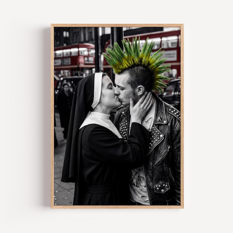 May include: A black and white photograph featuring a person in a black and white habit kissing a person with a bright green mohawk hairstyle wearing a black leather jacket with metal studs, set against a blurred urban background with a red bus.
