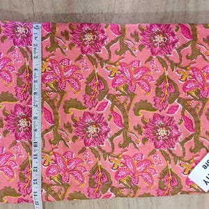 May include: Pink fabric with a floral pattern in shades of pink and brown. A measuring tape shows the fabric is approximately 14 inches long. The tag reads TEXTILECITY Store.