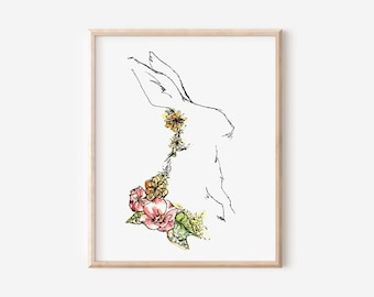 May include: A framed art print showing a minimalist line drawing of a rabbit. The rabbit is outlined in black ink, with a colourful floral arrangement adorning its body. The flowers are in shades of pink, yellow, and green.