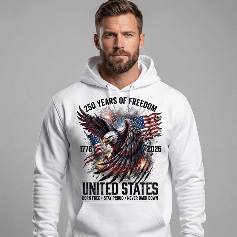 Pu&ograve; includere: Felpa con cappuccio bianca con un design grafico. Il design presenta un'aquila con le ali spiegate, bandiere americane e il testo "250 YEARS OF FREEDOM 1776-2026 UNITED STATES BORN FREE STAY PROUD NEVER BACK DOWN."