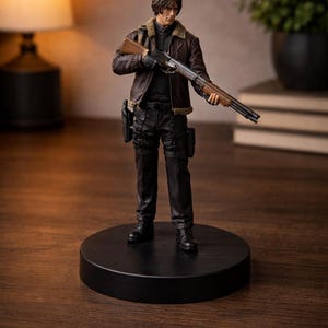 May include: A detailed figurine of a character from a video game, holding a shotgun. The figure is dressed in a brown leather jacket with a fur collar, black pants, and boots. The figure stands on a black circular base.