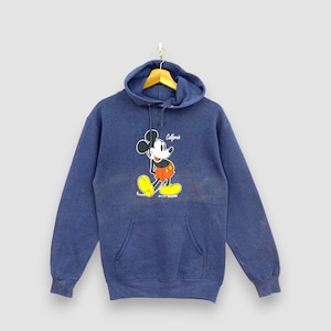 Peut inclure: Un sweat à capuche bleu avec un dessin de Mickey Mouse en short rouge et chaussures jaunes. Le mot "California" est au-dessus de la tête de Mickey. Le sweat-shirt a une poche avant et une capuche à cordon.