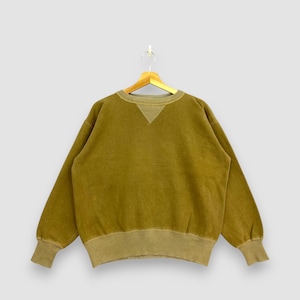 May include: Olive green sweatshirt with a crew neck and long sleeves. The sweatshirt has ribbed cuffs and a ribbed hem. The neckline features a triangular design. The garment is hanging on a wooden hanger against a light gray background.