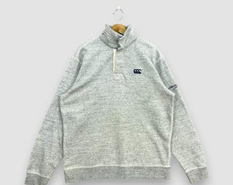 Jersey de rugby Canterbury vintage Y2K, gris jaspeado, con cuello y medio botón, estilo deportivo, con logo bordado, talla L.
