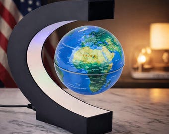 Op de afbeelding: Een zwevende wereldbol met een gedetailleerde wereldkaart, zwevend in een zwart, C-vormig frame. Het frame heeft een witte lichtstrip. De wereldbol is blauw en groen, en de basis is zwart.