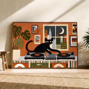 Könnte beinhalten: Ein gerahmter Kunstdruck, der eine schwarze Katze zeigt, die mit zwei Plattenspielern und einem Mischpult auflegt. Im Hintergrund ist eine nächtliche Skyline durch ein Fenster mit einer Mondsichel, eine Monstera-Pflanze und Wandbilder.