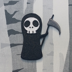 Op de afbeelding: Zwart-witte geborduurde patch van een cartoon Grim Reaper die een zeis vasthoudt. De Grim Reaper heeft een wit schedelgezicht met grote zwarte ogen.