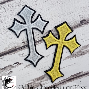 Può includere: Due toppe ricamate da stirare a forma di croce. Una è argentata e l'altra è dorata.