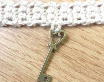 Brass key charm on crochet choker