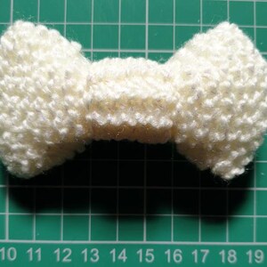 011, Gebreide strik broche in witte wol met metallic glitterdraad