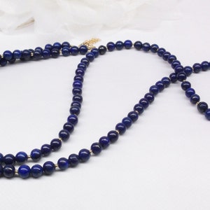 May include: A blue lapis lazuli beaded necklace and bracelet set. The necklace is layered and the bracelet is a single strand.