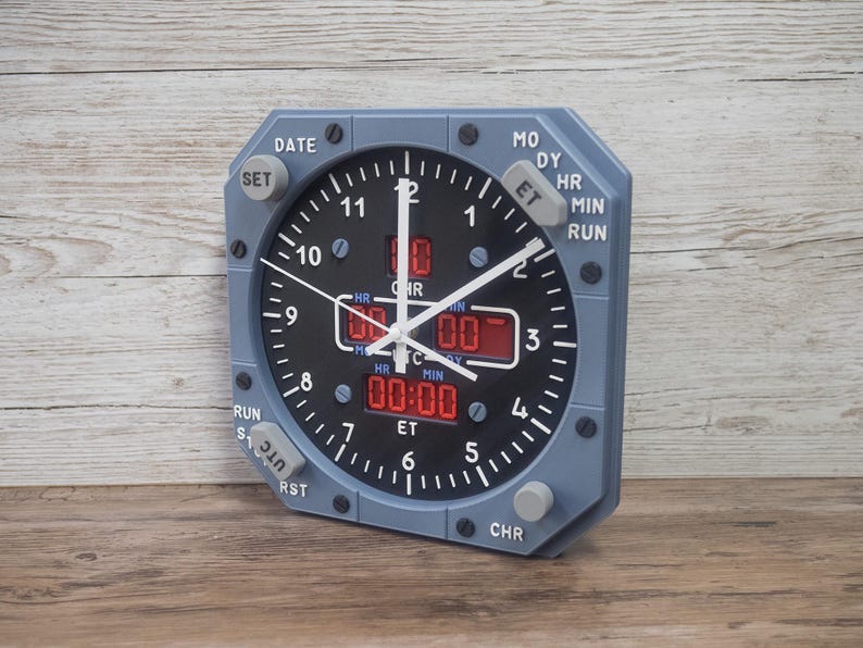 Pilot gift wall clock modeled after an Airbus aircraft cockpit chronometer. This aviation decor features realistic flight instrument details, a grey bezel, and digital time displays.