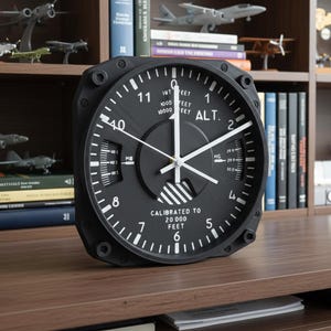 Pilot gift wall clock modeled after a Cessna aircraft cockpit altimeter. This aviation decor features realistic flight instrument details, a black bezel, and white dial lettering and clock hands.