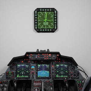 Fighter jet pilot wall clock in the style of a MFD (multi function display). Square black housing with light grey buttons and green lcd displaying time.