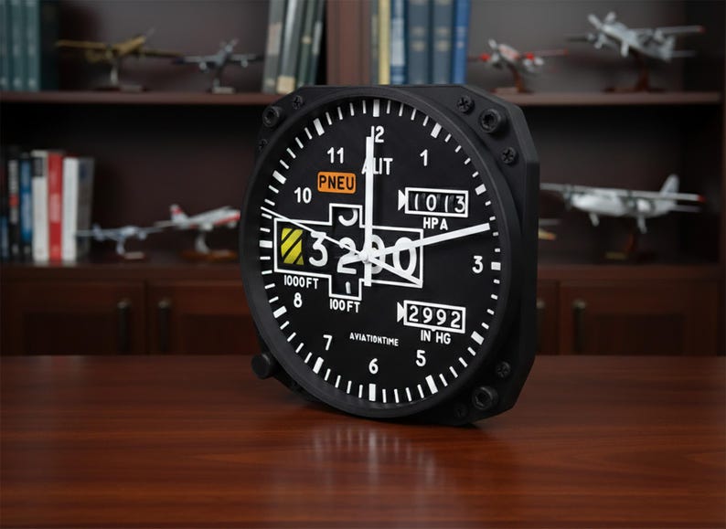 May include: Black aviation-themed clock with white numerals and hands. The clock face displays the numbers 1 through 12, along with the text "PNEU", "LIT", "HPA", and "IN HG". The clock reads 3200 and is set against a dark wooden surface.
