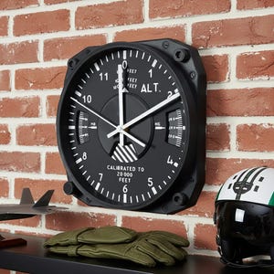 Pilot gift wall clock modeled after a Cessna aircraft cockpit altimeter. This aviation decor features realistic flight instrument details, a black bezel, and white dial lettering and clock hands.