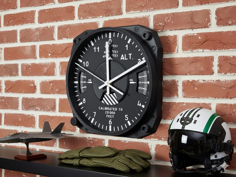 Pilot gift wall clock modeled after a Cessna aircraft cockpit altimeter. This aviation decor features realistic flight instrument details, a black bezel, and white dial lettering and clock hands.