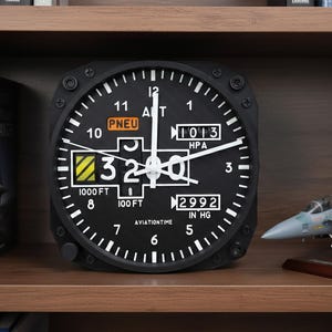 May include: Black aviation-themed wall clock with white numerals and hands. The clock face displays altitude and pressure readings, with the text "PNEU" and "AVIATIONTIME". A model airplane sits on the shelf.