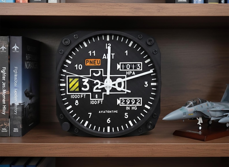 May include: Black aviation-themed wall clock with white numerals and hands. The clock face displays altitude and pressure readings, with the text "PNEU" and "AVIATIONTIME". A model airplane sits on the shelf.