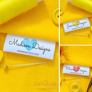 Op de afbeelding: Witte stoffen labels met de tekst "Madison Designs" en een blauw hart, "Jessica Designs" met een geel hart en "Claire's Designs" met een rood hart. Alle labels lezen "HANDMADE WITH LOVE". De achtergrond is gele stof.