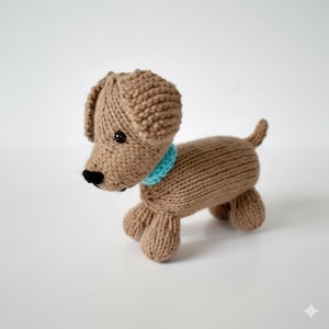 May include: A knitted brown dog toy with a light blue collar. The dog has black eyes and a black nose. The toy is made of a soft, textured yarn and has four small legs and a small tail.