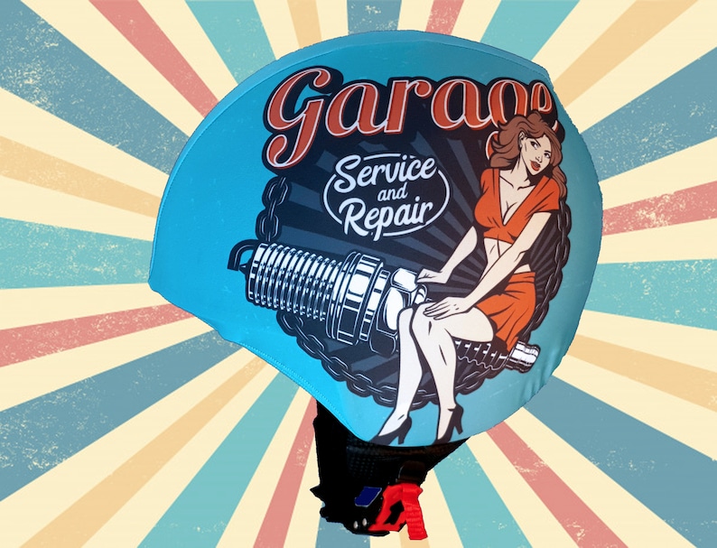 May include: A blue helmet with a vintage-style graphic of a woman sitting on a spark plug. The graphic includes the text "Garage Service and Repair".