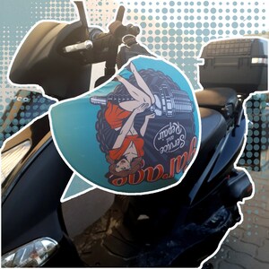 May include: A black scooter with a turquoise and white seat cover featuring a pin-up girl illustration and the text "Service and Repair".