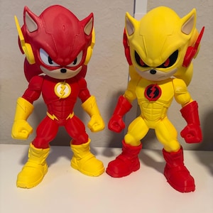 Peut inclure: Deux figurines debout ressemblant à un hybride entre un hérisson et un personnage de super-héros rapide. La figurine de gauche est principalement rouge avec des accents jaunes et un emblème d'éclair. Celle de droite est jaune avec des accents rouges.